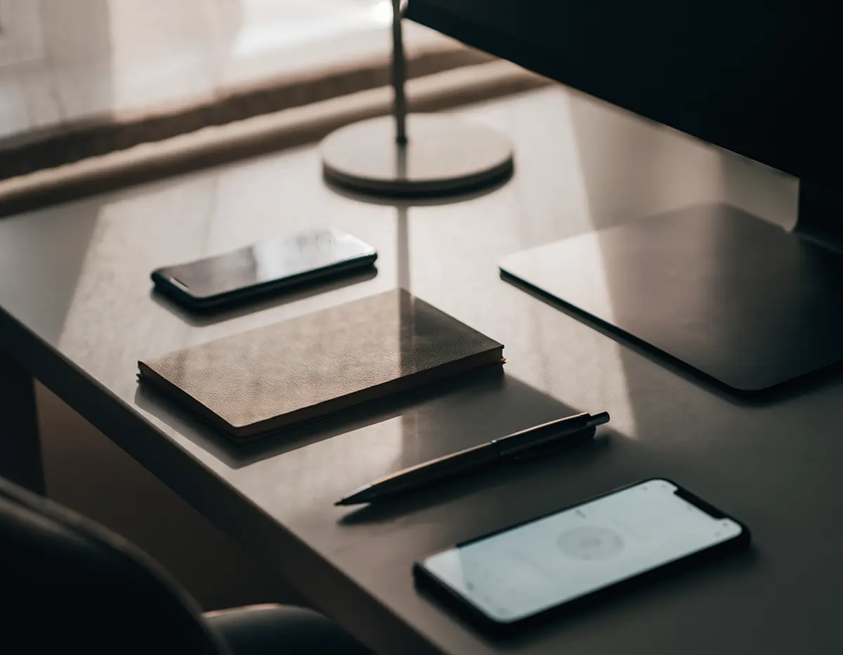 机の上にスマートフォンやメモなどを並べている画像